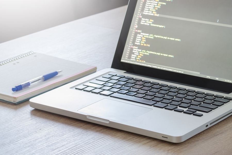 Laptop mit Quellcode auf einem Schreibtisch
